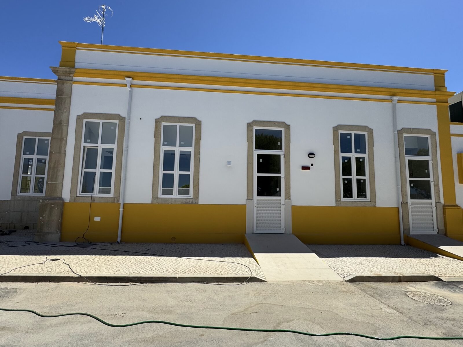 Fachada algarvia caiada com janelas de PVC brancas recém-instaladas