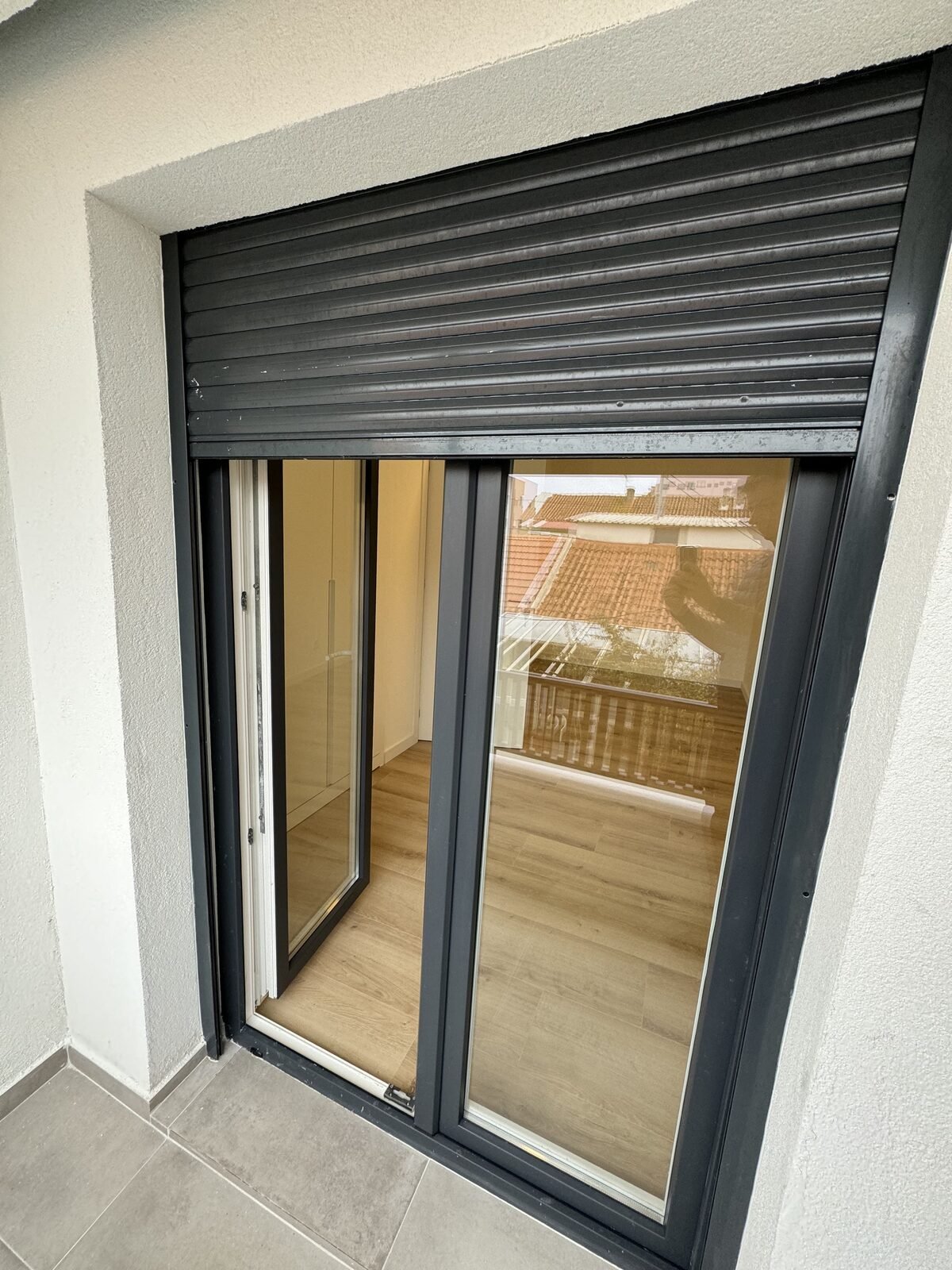 Porta de correr em PVC com estore exterior, aberta para a sala